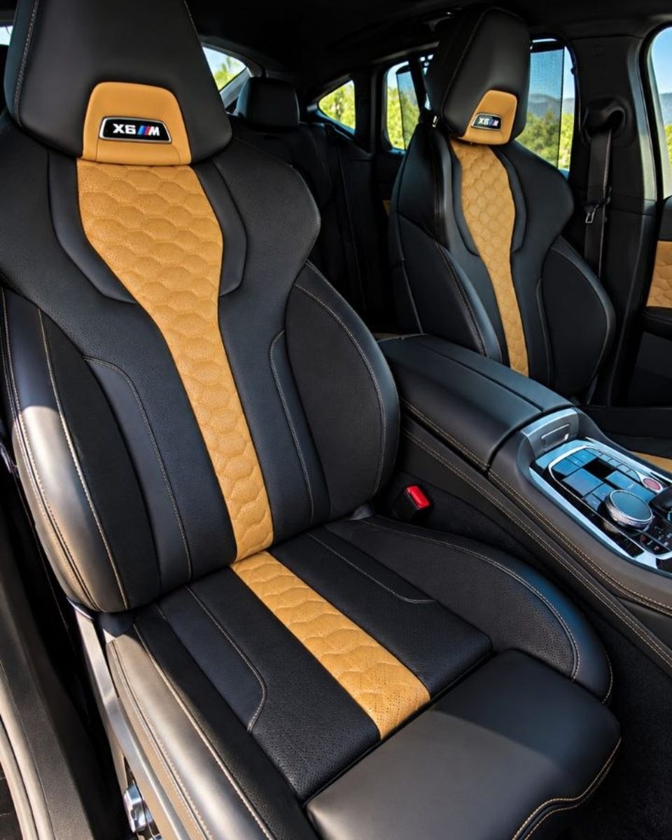 BMW X6 M front seats with black upholstery, contrasting tan inserts and sculpted sport seat design.