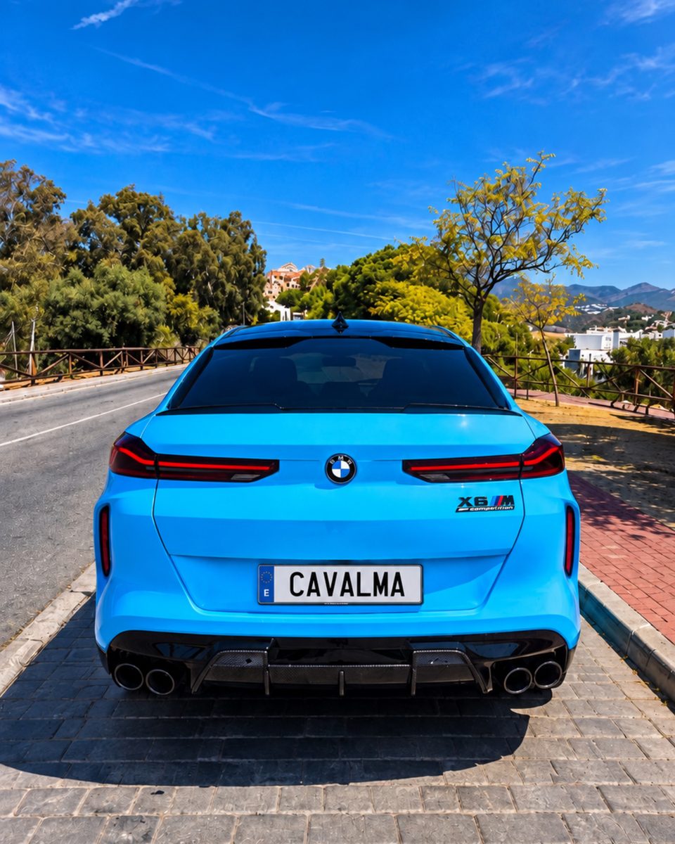 Blue BMW X6 M rear view showing the sculpted tailgate, rear lighting, quad exhaust outlets and black rear diffuser.