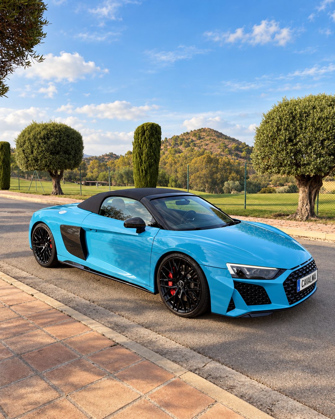 Blue Audi R8 Spyder rental in Marbella, front three-quarter view with black soft top and CAVALMA plate.