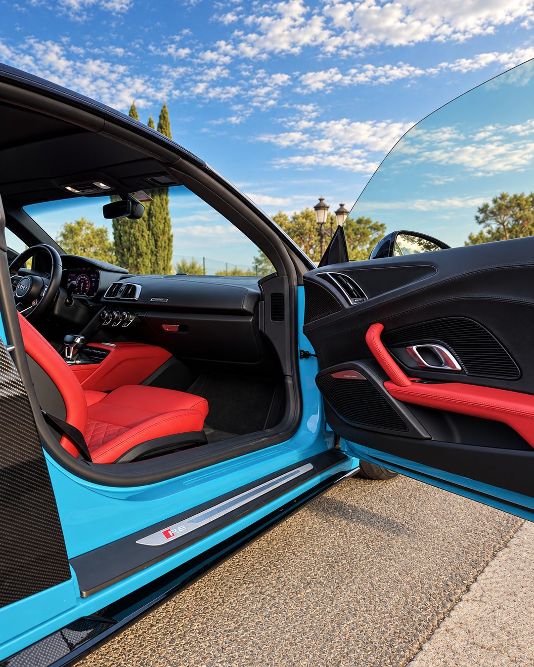 Audi R8 Spyder red leather passenger interior with open door, black trim and sports car cabin details.