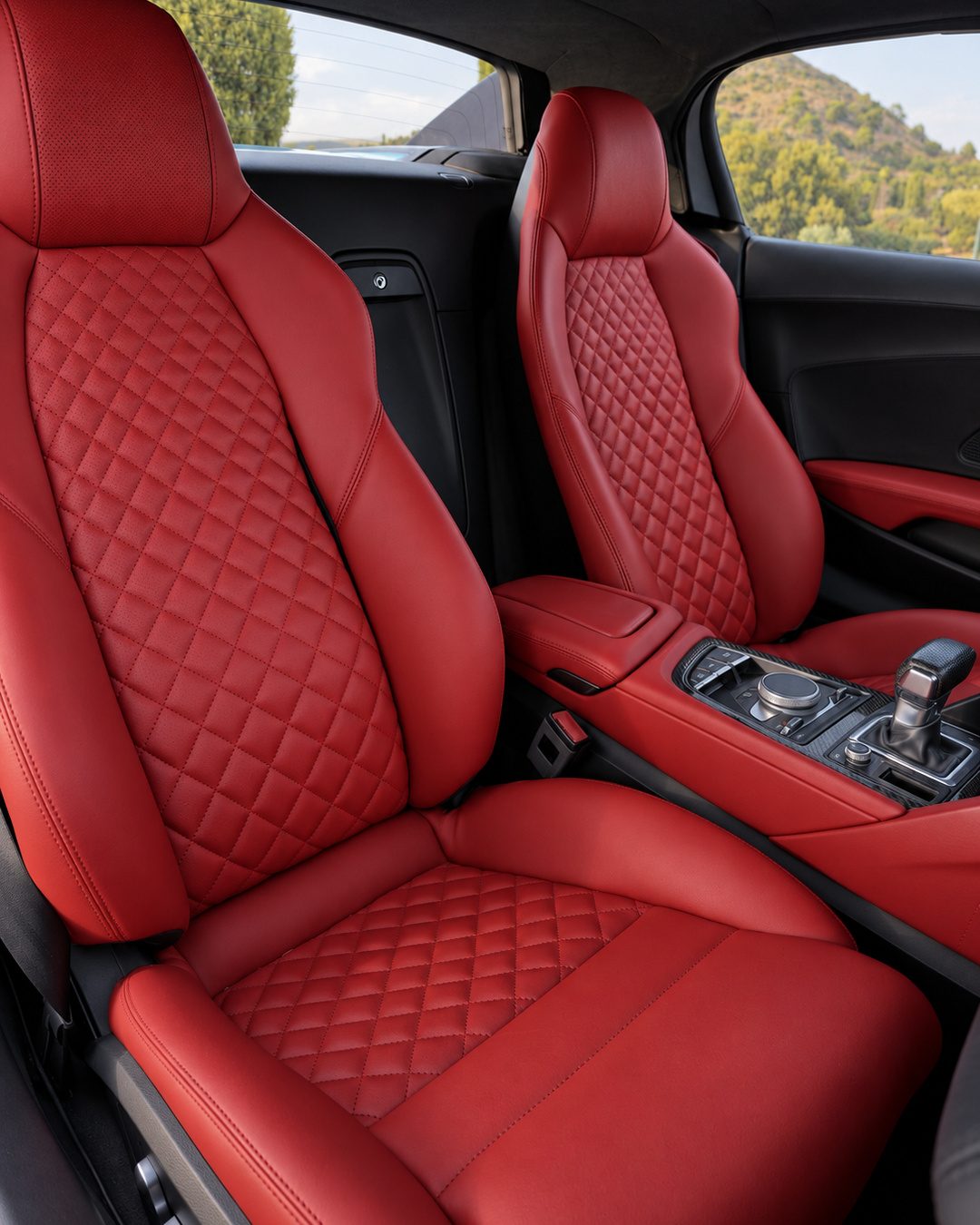 Close-up of the Audi R8 Spyder red leather sports interior, diamond-stitched seats and centre controls.