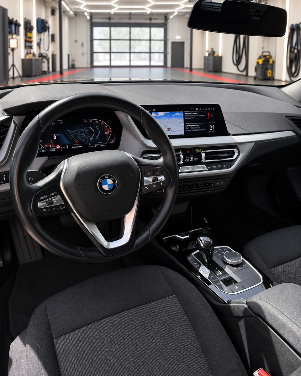 BMW 1 Series driver’s cockpit featuring the BMW steering wheel, digital instrument display, central infotainment screen, dashboard and gear selector.