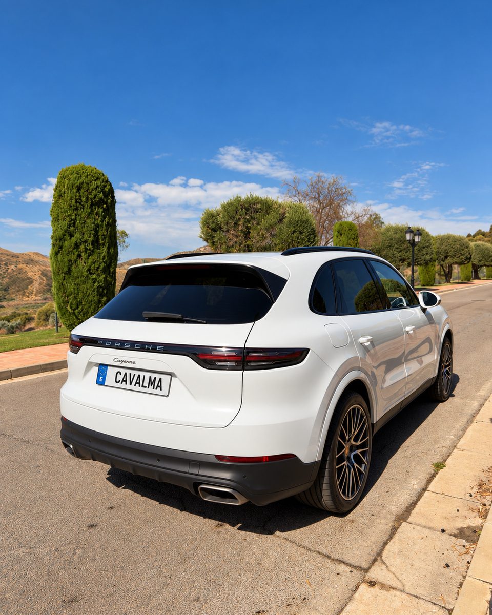 Rear three-quarter view of the white 2020 Porsche Cayenne showing the Porsche rear light bar, Cayenne badging and rear bumper.